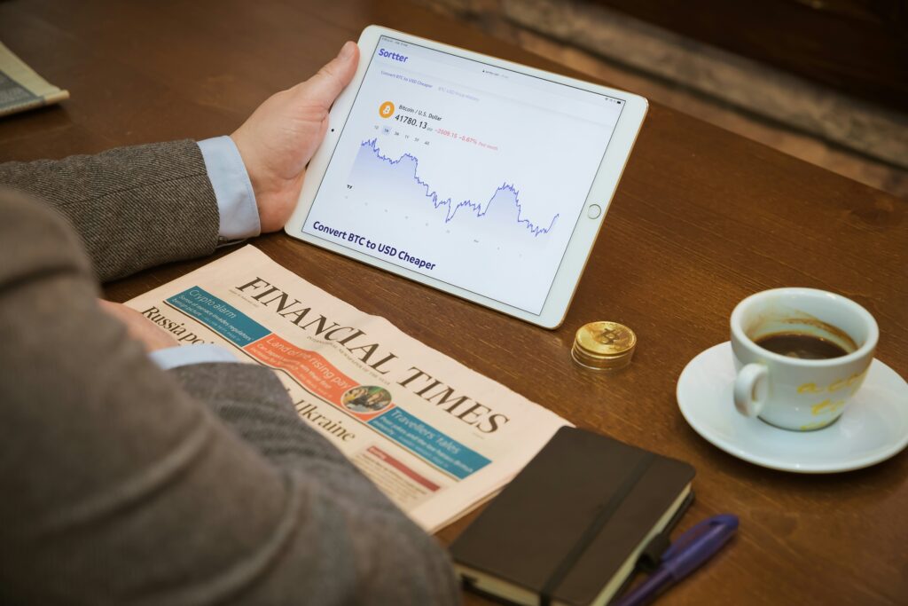 investment charts on screen with coffee cup